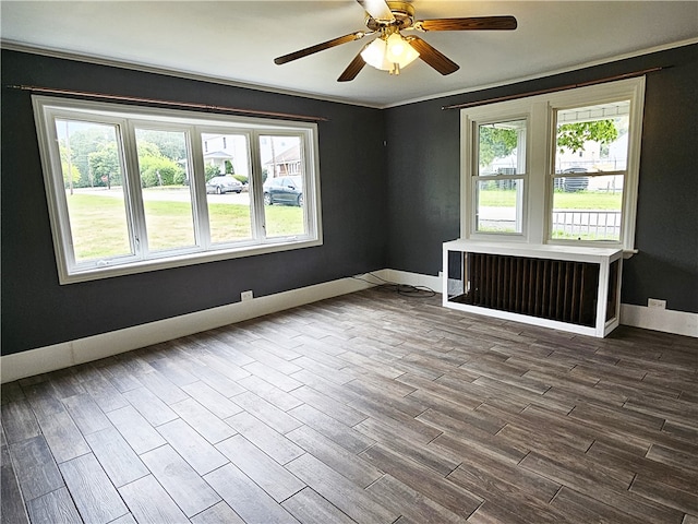 empty room with radiator heating unit, ceiling fan, hardwood / wood-style floors, and crown molding