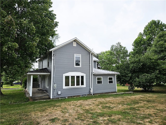 rear view of house with a yard and covered porch