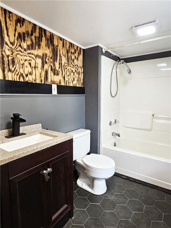 bathroom with tile patterned flooring, shower / tub combination, toilet, visible vents, and vanity