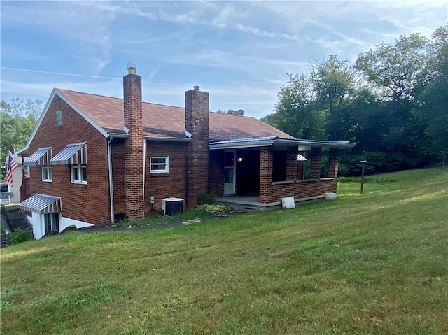 back of house with a yard and central AC