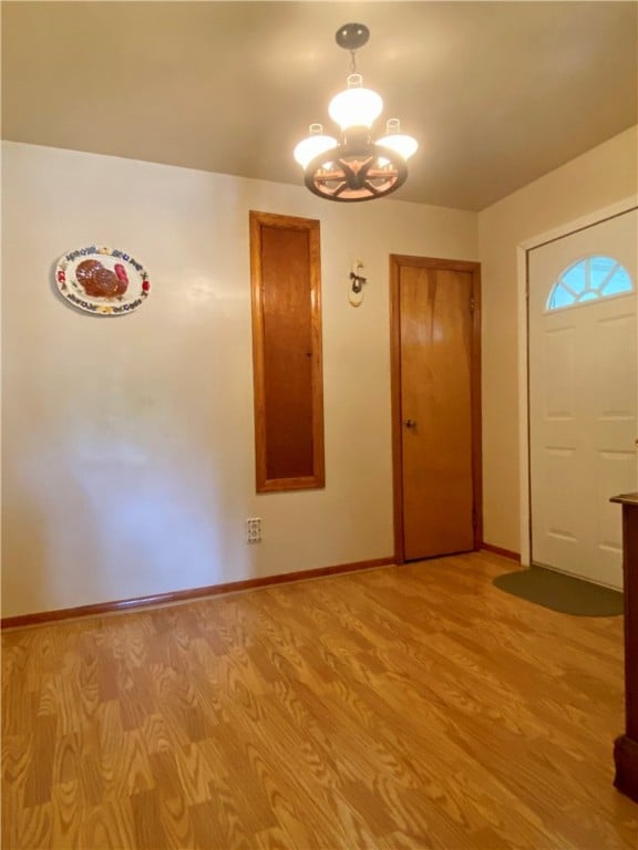 foyer entrance with a notable chandelier and light hardwood / wood-style flooring