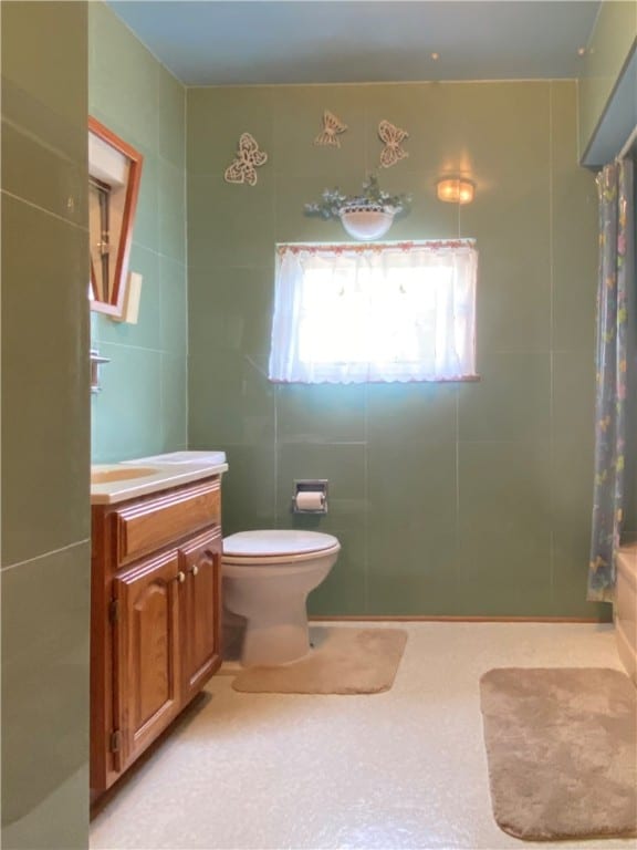 bathroom with tile walls, vanity, a shower with curtain, and toilet