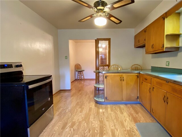 kitchen featuring kitchen peninsula, stainless steel range with electric stovetop, light wood-type flooring, and ceiling fan