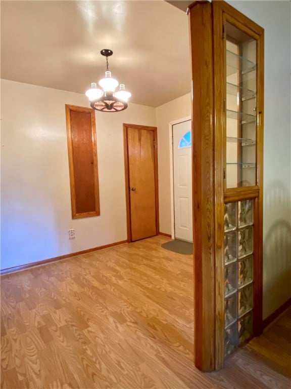 interior space with an inviting chandelier and light hardwood / wood-style flooring