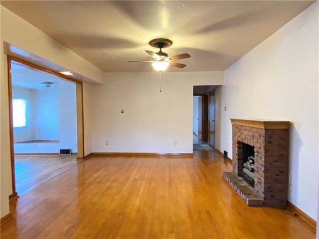 unfurnished living room featuring ceiling fan, hardwood / wood-style flooring, and a fireplace