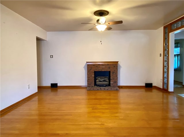 unfurnished living room featuring ceiling fan, light hardwood / wood-style flooring, and a brick fireplace