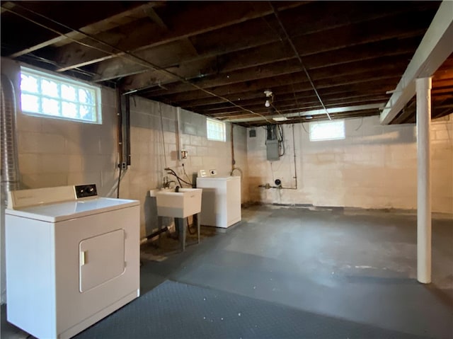 basement featuring sink, electric panel, and washing machine and clothes dryer