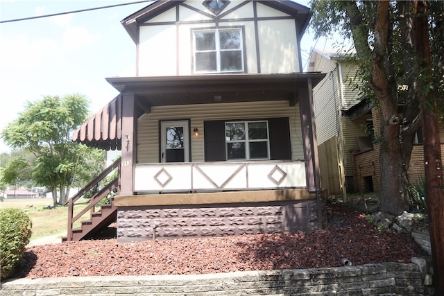 tudor home featuring covered porch