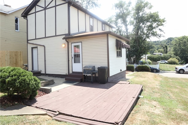 back of house featuring a wooden deck and a lawn