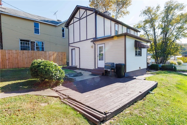 rear view of house featuring a yard and a deck