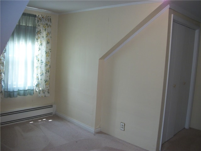 empty room with crown molding, carpet, and a baseboard radiator