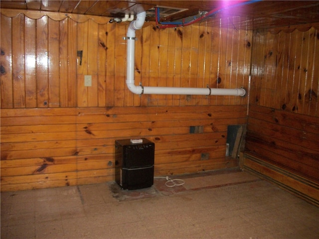 basement with tile patterned floors and wooden walls