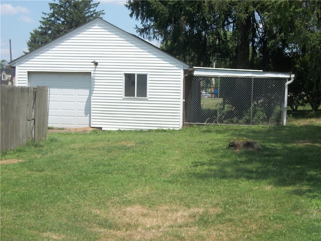 exterior space with a garage, an outbuilding, and a lawn