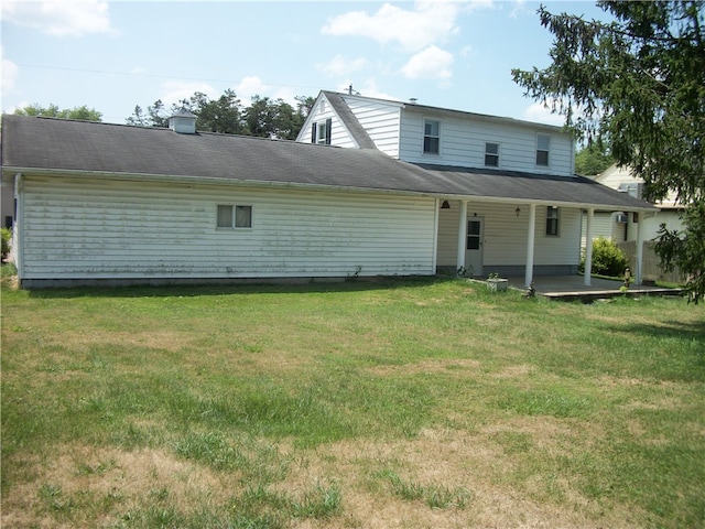 rear view of property featuring a lawn