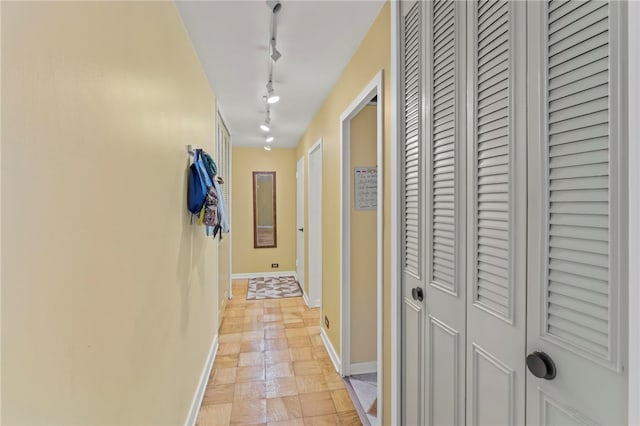 corridor with track lighting and light tile patterned floors