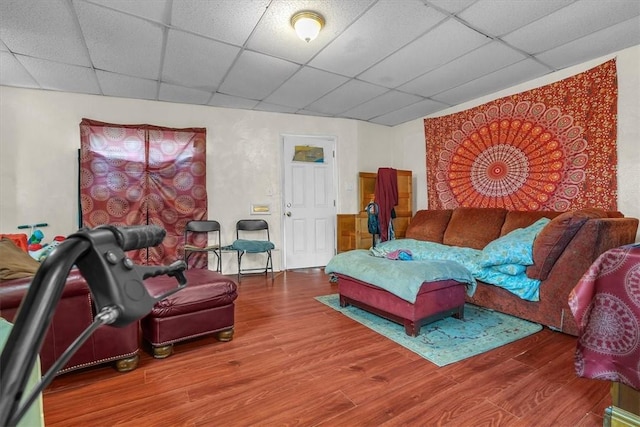 living room featuring wood-type flooring and a drop ceiling