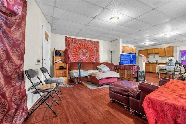 living room featuring a paneled ceiling and hardwood / wood-style floors