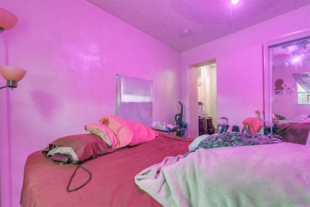 bedroom with vaulted ceiling and a textured ceiling