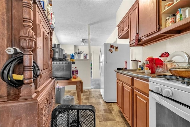 kitchen with a textured ceiling and white appliances