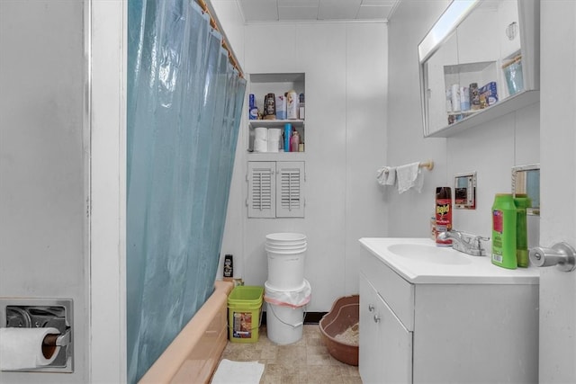 bathroom with tile patterned flooring, shower / bath combo with shower curtain, and vanity