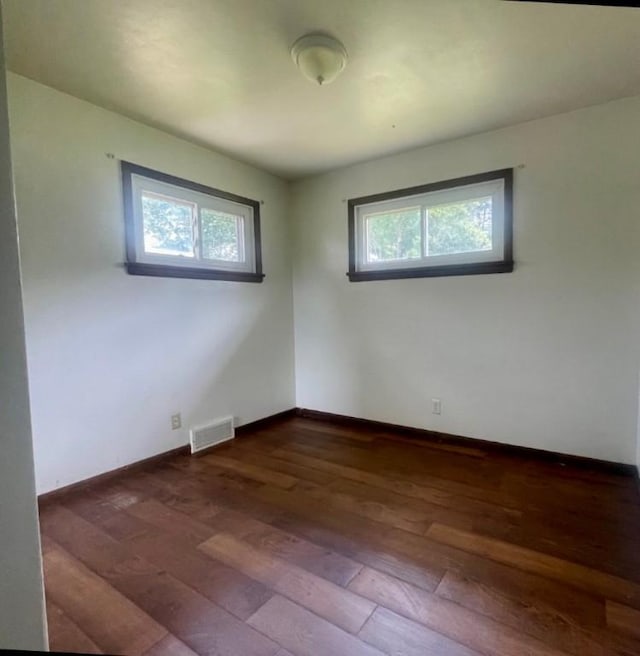 empty room with dark hardwood / wood-style flooring