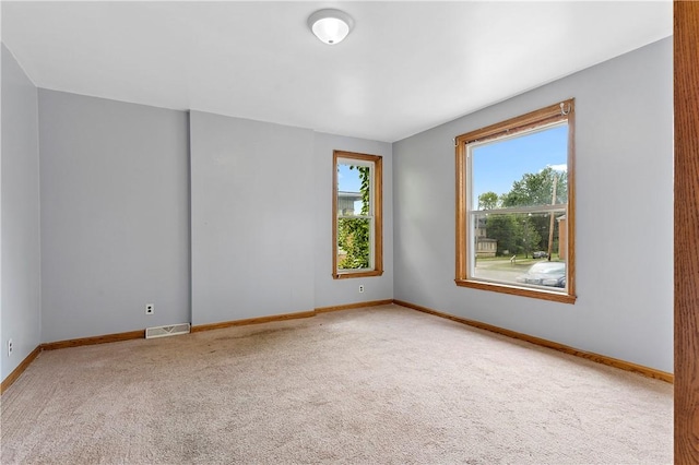 spare room with visible vents, baseboards, and carpet floors