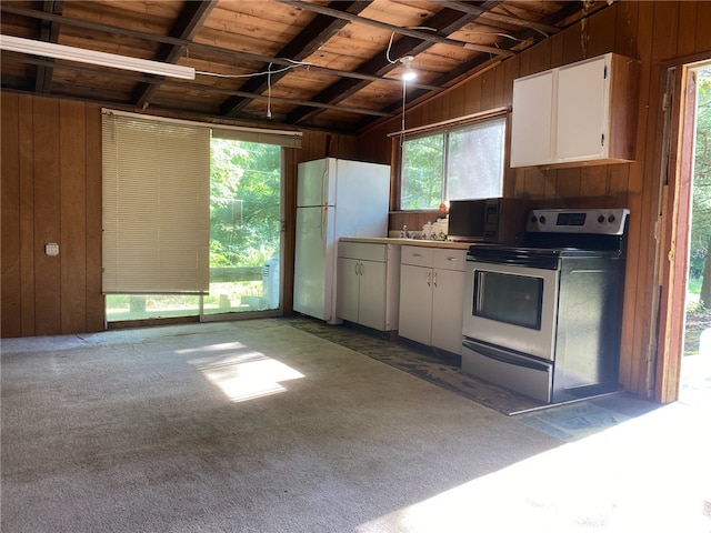 kitchen featuring wooden walls, stainless steel electric stove, vaulted ceiling with beams, and wood ceiling