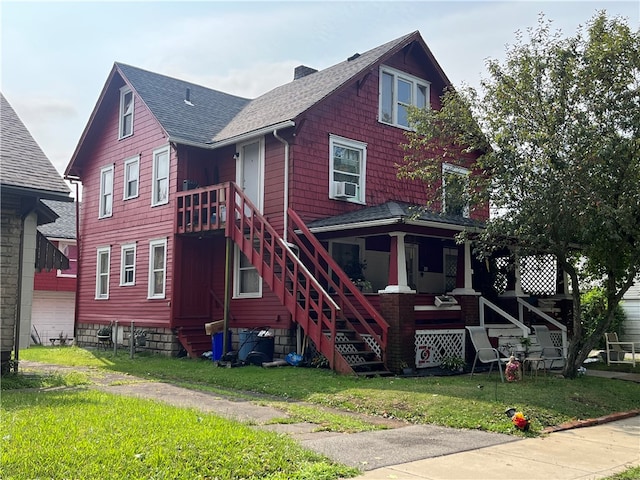 exterior space with a front yard, cooling unit, roof with shingles, a porch, and stairs