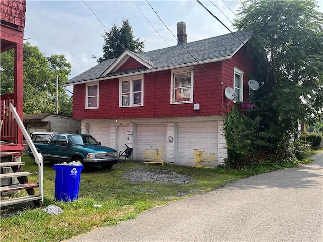 view of property exterior with a garage, a chimney, driveway, and a shingled roof