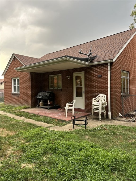 back of property with a lawn and a patio