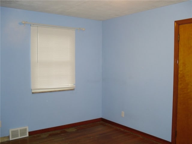 unfurnished room with dark hardwood / wood-style flooring