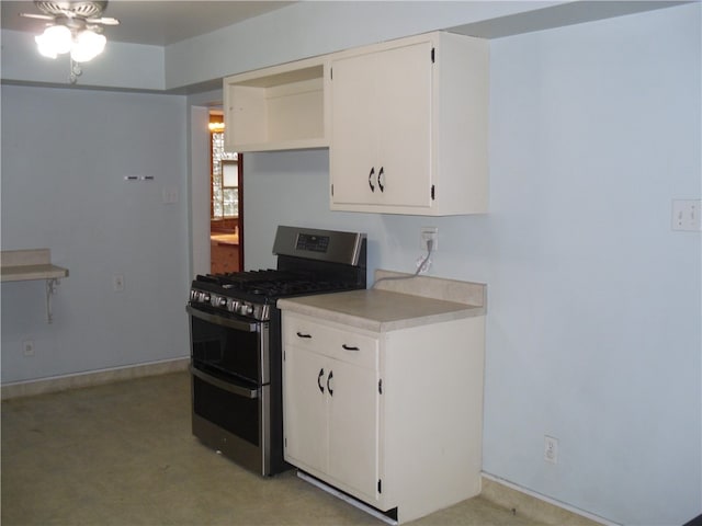 kitchen with gas range, ceiling fan, white cabinets, and light colored carpet