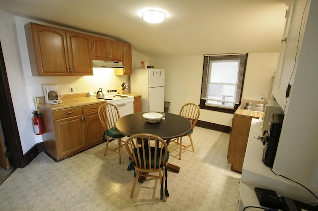 kitchen featuring sink, lofted ceiling, light tile patterned floors, and white appliances