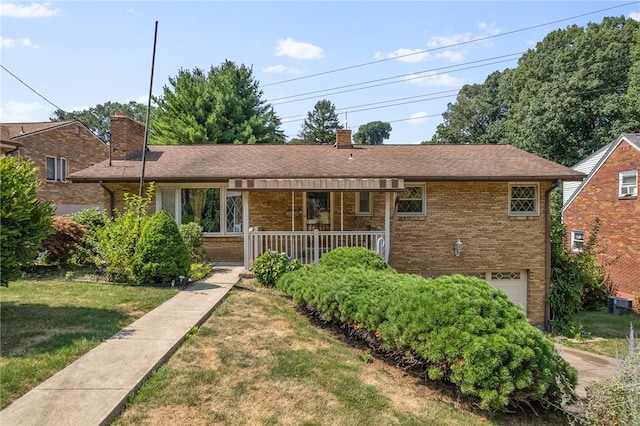 ranch-style home with a garage, covered porch, and a front lawn