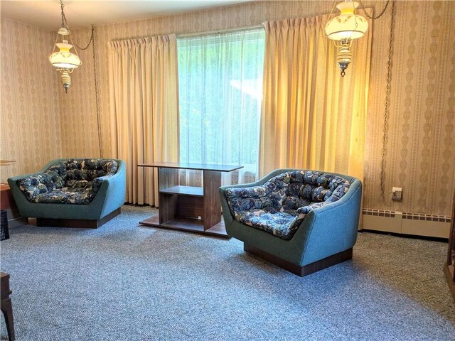 sitting room with a baseboard heating unit and carpet flooring