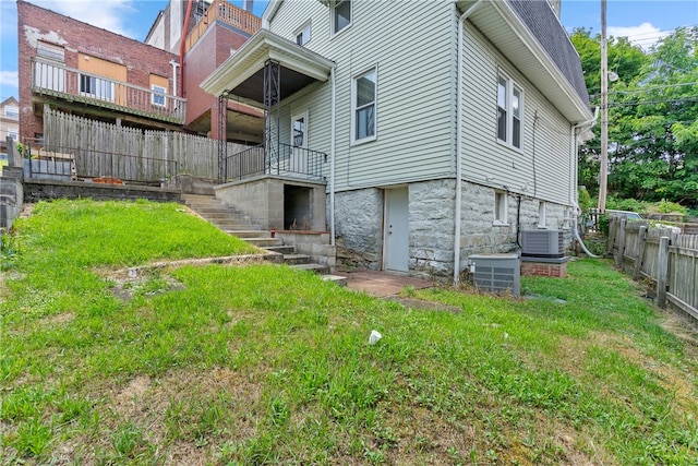 exterior space with central AC and a yard