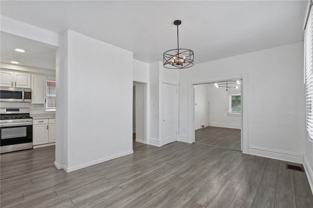 unfurnished dining area with light hardwood / wood-style flooring and a notable chandelier