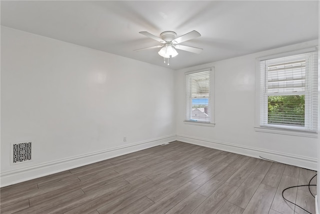 unfurnished room with light wood-type flooring and ceiling fan