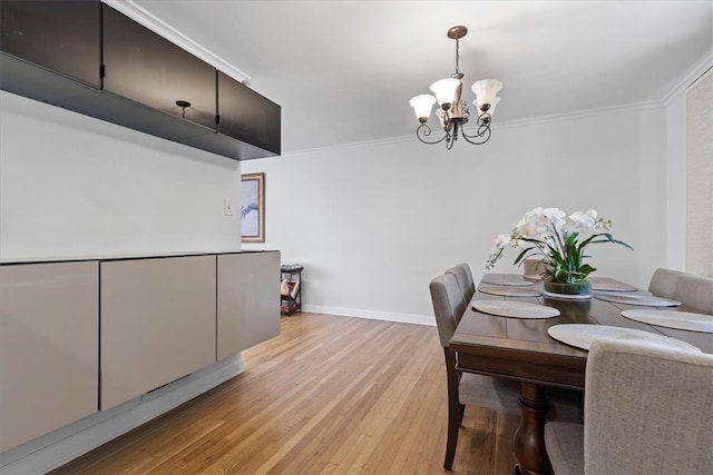 dining room with crown molding, light hardwood / wood-style floors, and a notable chandelier