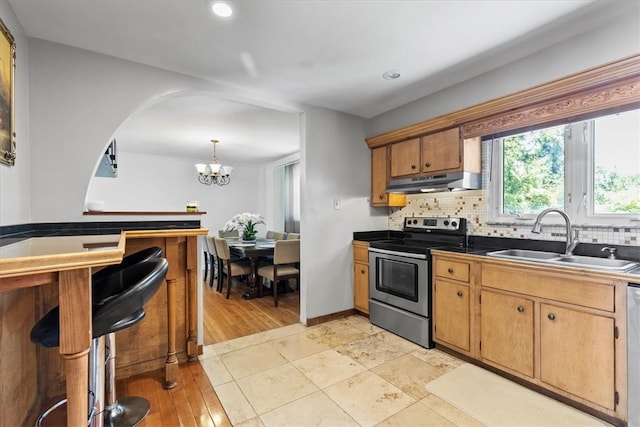 kitchen featuring sink, appliances with stainless steel finishes, tasteful backsplash, decorative light fixtures, and a chandelier