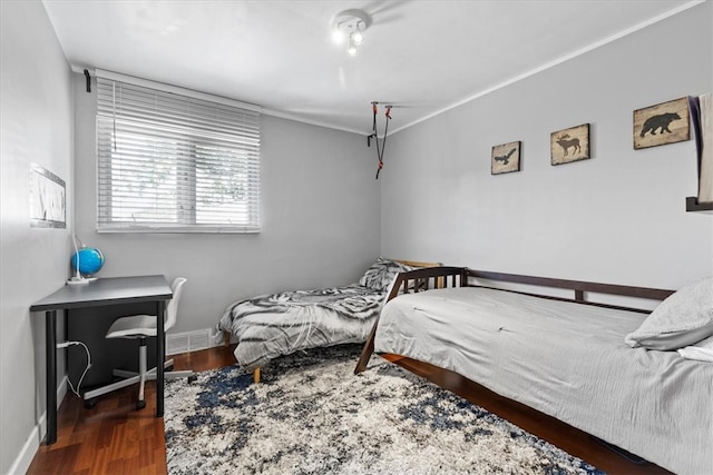 bedroom with dark hardwood / wood-style floors and crown molding