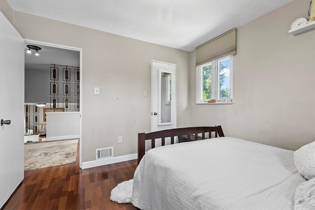 bedroom with dark hardwood / wood-style floors