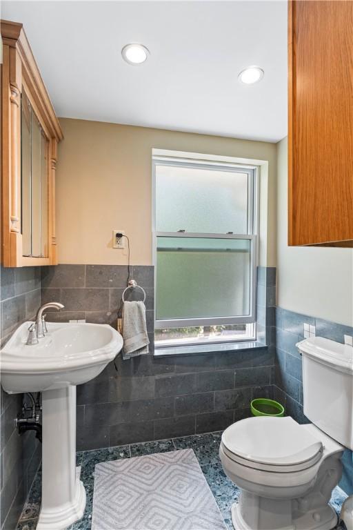 bathroom featuring tile patterned floors, tile walls, tasteful backsplash, and toilet