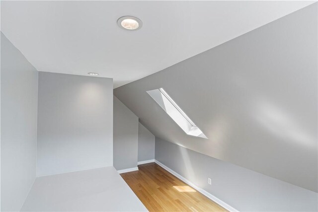 bonus room featuring hardwood / wood-style flooring and lofted ceiling with skylight