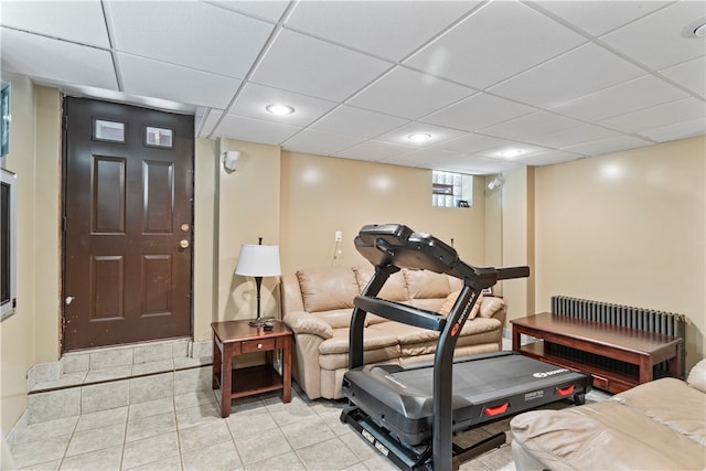 exercise area with a drop ceiling and light tile patterned floors