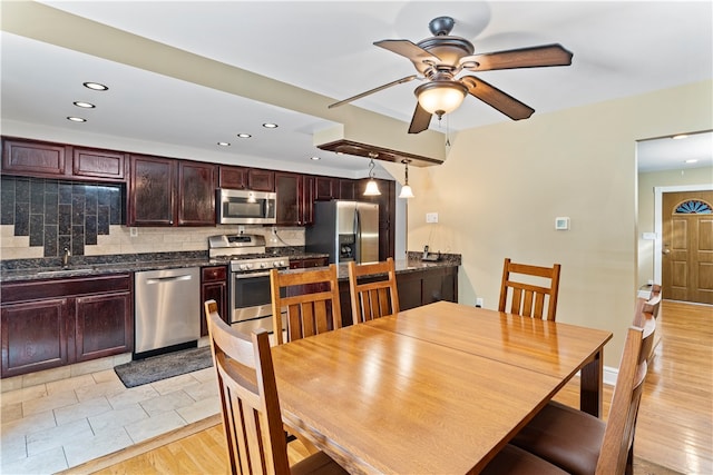 dining room with sink, ceiling fan, and light wood-type flooring