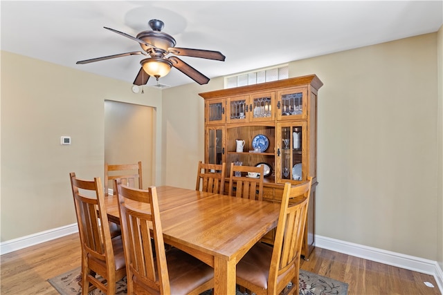 dining area with hardwood / wood-style flooring and ceiling fan