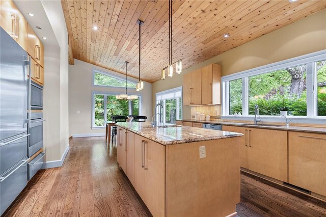 kitchen with backsplash, wood-type flooring, wooden ceiling, and a center island with sink