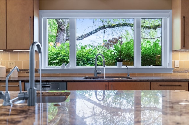 interior details featuring sink, dark stone countertops, and backsplash