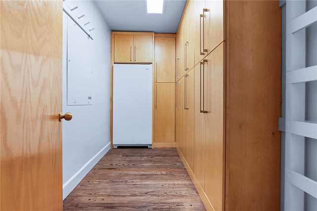 kitchen with refrigerator, hardwood / wood-style flooring, and light brown cabinetry